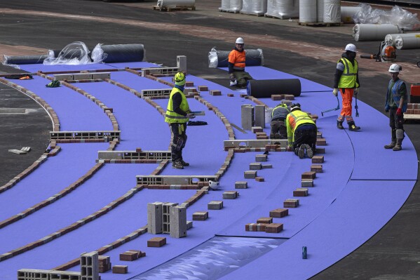 The purple athletics track at the Olympic Stadium, currently known as Stade de France, is being installed, in Saint-Denis, north of Paris, Tuesday, April 9, 2024. The Olympic Stadium will host the athletics events at the Paris 2024 Olympic Games. (AP Photo/Aurelien Morissard)