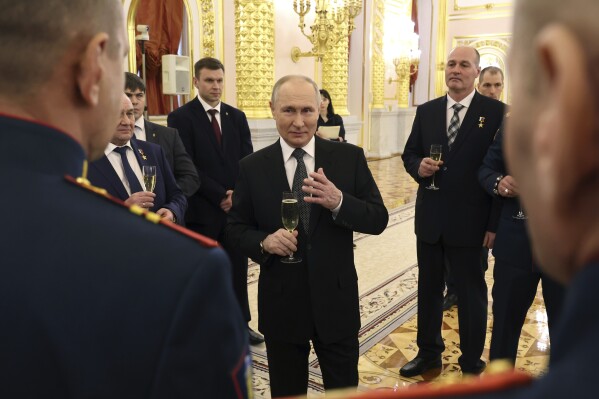 Russian President Vladimir Putin talks with awarded Russian servicemen after a ceremony to present Gold Star medals to Heroes of Russia on the eve of Heroes of the Fatherland Day at the St. George Hall of the Grand Kremlin Palace in Moscow, Russia, Friday, Dec. 8, 2023. (Mikhail Klimentyev, Sputnik, Kremlin Pool Photo via AP)