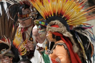 ARCHIVO -El papa Francisco posa para una foto familiar con un grupo de peregrinos mexicanos que visten atuendos tradicionales en la audiencia general semanal en el Vaticano, el 10 de abril de 2022. (AP Foto/Andrew Medichini, Archivo)