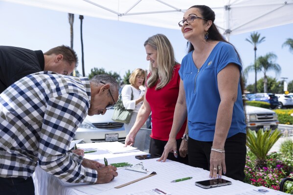 Revival Fellowship volunteers Janie Booth, left, and Lucky Harutunian register voters during a Comeback California Tour event, Saturday, Sept. 21, 2024, in Menifee, Calif. (AP Photo/Zoë Meyers)