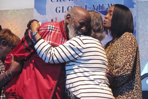 Wilbert Gardner, left, hugs Katrena Alexander while Alexander's daughter, Regina Brinson, right, looks on during a news conference Tuesday, Oct. 22, 2024, in Jacksonville, Fla, A dock gangway collapse happened as people were leaving a cultural festival on Sapelo Island, Georgia, on Saturday, Oct. 19, 2024. Alexander's brother, Isaiah Thomas, was among the dead. Gardner had a friend who was hospitalized with injuries. (AP Photo/Russ Bynum)