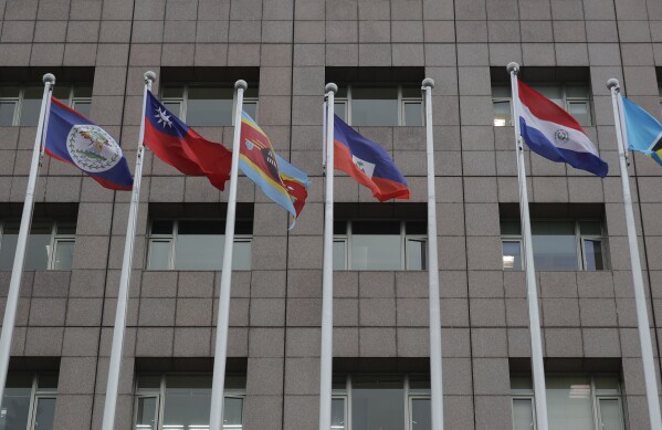 A pole, third from right, where Nauru national flag used to fly is vacant outside the Diplomatic Quarter building in Taipei, Taiwan, Monday, Jan. 15, 2024. The Pacific Island nation of Nauru says it is switching diplomatic recognition from Taiwan to China. The move on Monday leaves Taiwan with 12 diplomatic allies around the world. Taiwan now has official ties with 11 countries and the Vatican. (AP Photo/Chiang Ying-ying)