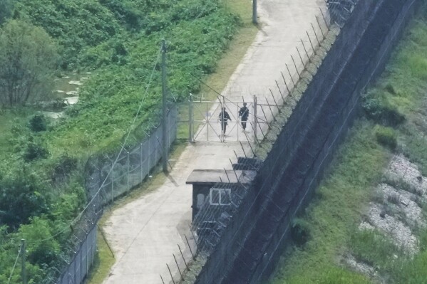 South Korean army soldiers patrol along the barbed-wire fence in Paju, South Korea, near the border with North Korea, Friday, July 19, 2024. South Korea said Friday it has restarted blasting propaganda broadcasts into North Korea to retaliate against the North's latest round of trash-carrying balloon launches, a resumption of Cold War-style tactics that are raising animosities between the rivals.(AP Photo/Ahn Young-joon)