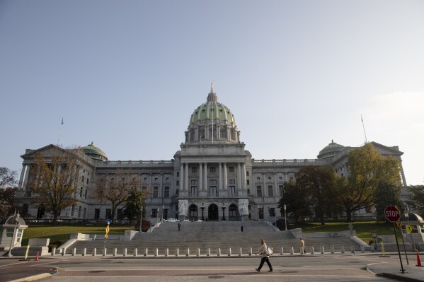 FILE - Pedestrians walk past the Pennsylvania Capitol in Harrisburg, Pa., Nov. 19, 2019. (AP Photo/Matt Rourke, File)