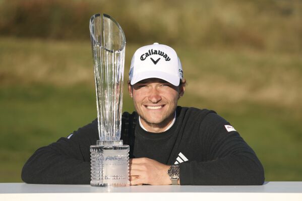 Denmark's Rasmus Hojgaard poses with the trophy after winning the Amgen Irish Open 2024 at Royal County Down in Newcastle, County Down, England, Sunday Sept. 15, 2024. (Peter Morrison/PA via AP)