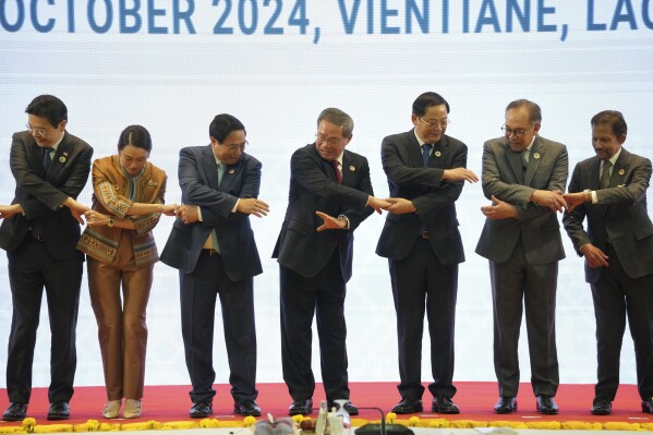 From left, Singapore's Prime Minister Lawrence Wong, Thailand's Prime Minister Paetongtarn Shinawatra, Vietnam's Prime Minister Pham Minh Chinh, Chinese Premier Li Qiang, Laos' Prime Minister Sonexay Siphandone, Malaysia's Prime Minister Anwar Ibrahim and Brunei Sultan Hassanal Bolkiah hold hands for a photo session during the 27th Association of Southeast Asian Nations (ASEAN)-China Summit in Vientiane, Laos, Thursday, Oct. 10, 2024. (AP Photo/Dita Alangkara)