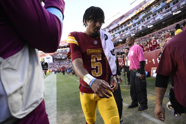 Washington Commanders quarterback Jayden Daniels walks off the field after getting injured during the first half of an NFL football game against the Carolina Panthers, Sunday, Oct. 20, 2024, in Landover, Md. (AP Photo/Nick Wass)